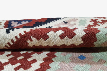 Close-up of the edge of a kilim rug with a woven pattern and fringe