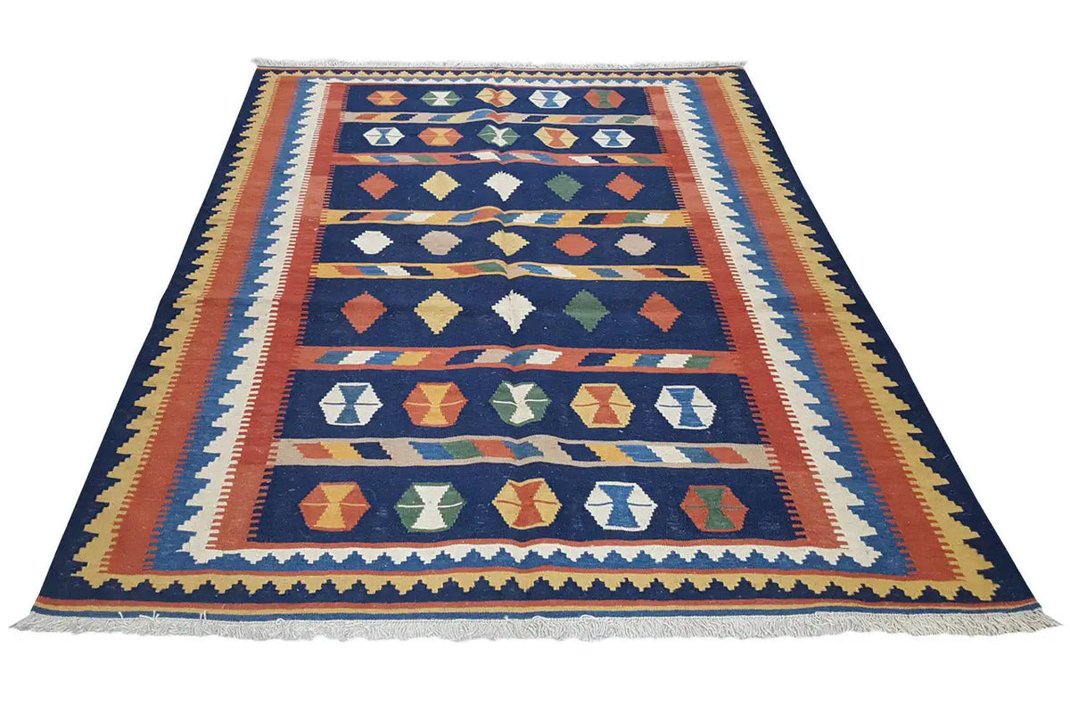 Kilim rug with a dark blue background and geometric patterns in orange, yellow, and green