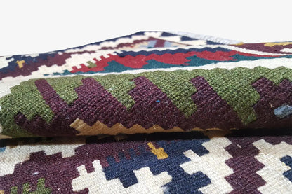 Close-up of the kilim: dense pile with green and burgundy patterns