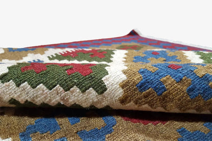 Close-up of the kilim fabric with multicolored cross and diamond motifs.