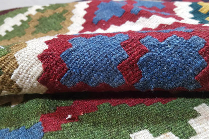 Close-up of carpet fabric: blue-red diamonds on a multicolored background