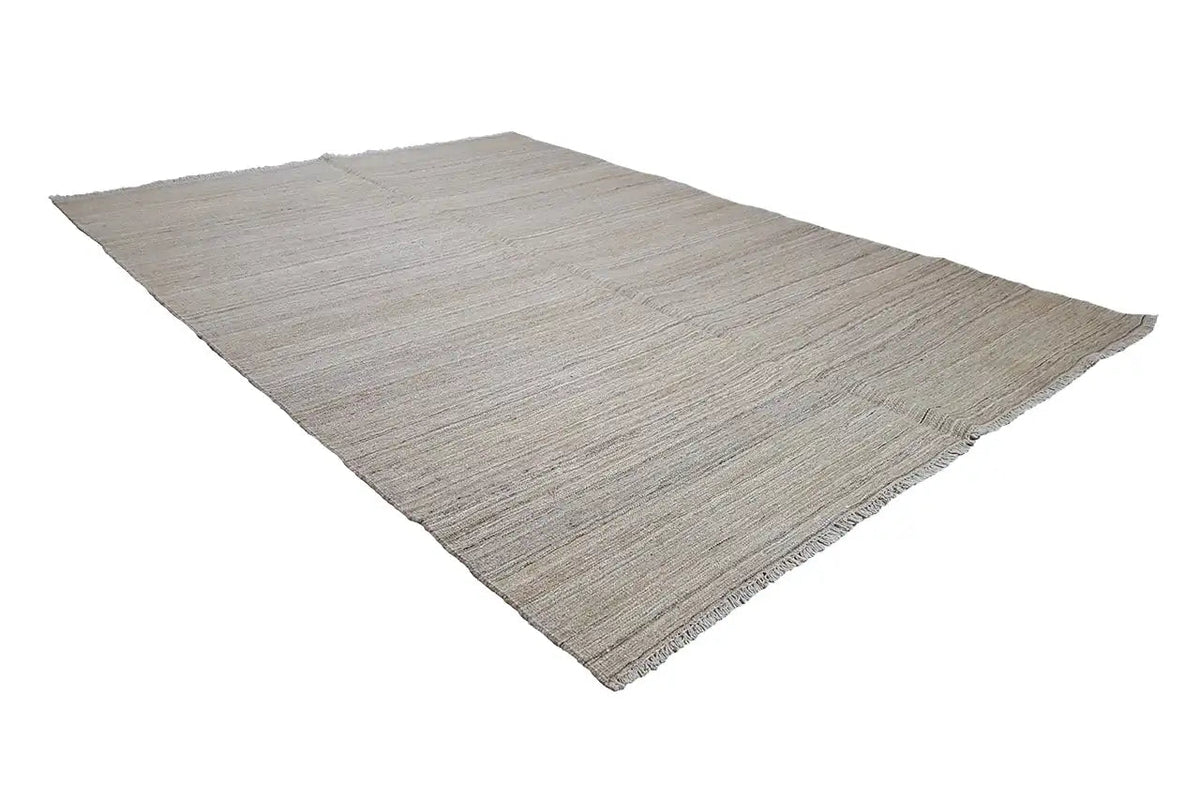 Kilim rug in light beige, diagonal view, flat weave texture, fringes