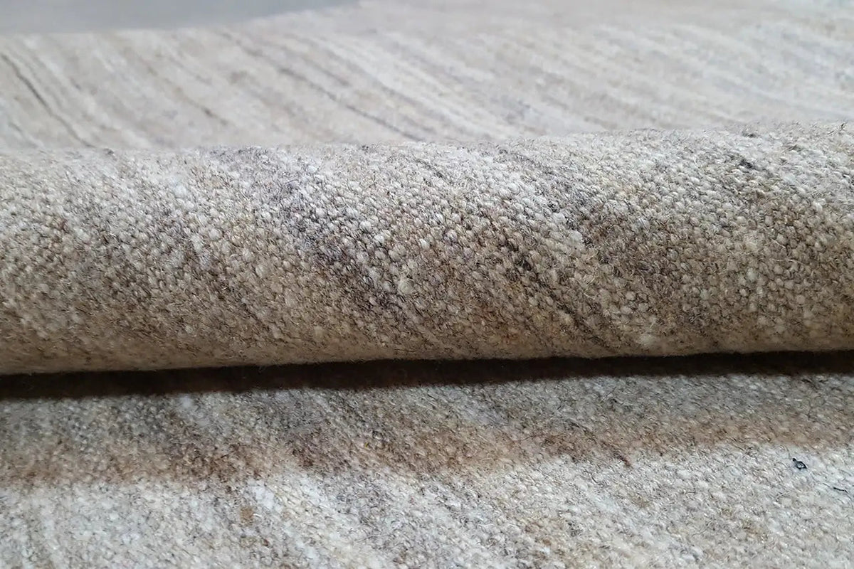 Close-up of the Kelim rug: mottled light beige-gray, dense weave