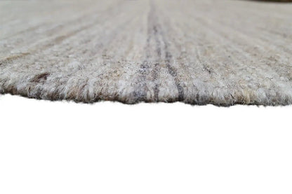 Kilim rug edge close-up, light beige-gray mottled fabric, selvedges visible