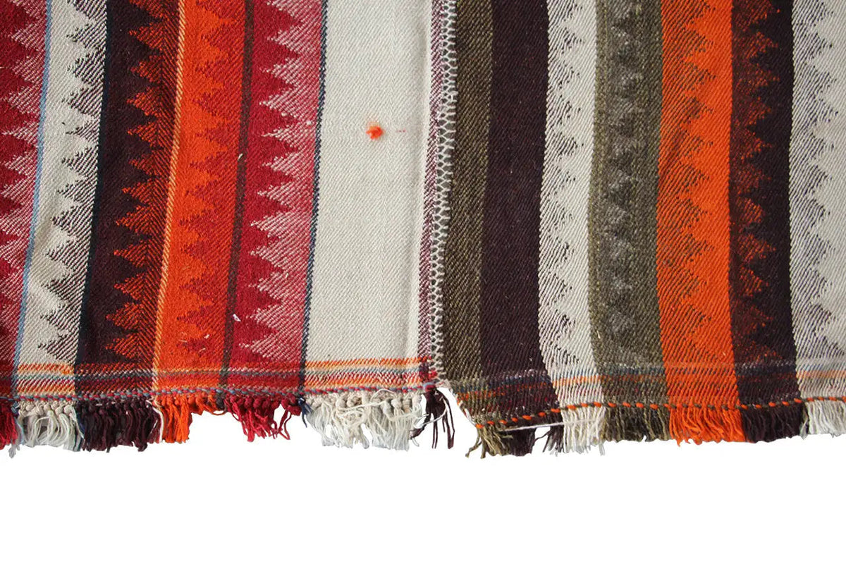 Jajim rug corner with fringe and stripes in orange, red, brown, and beige
