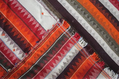 Close-up of a jajim rug: overlapping stripes and fringes at the seam