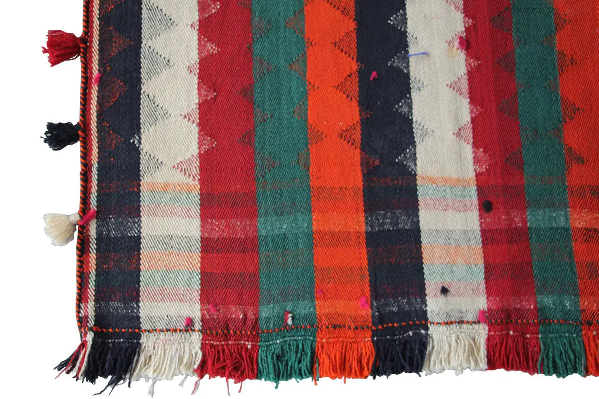 Jajim rug detail view: multicolored checkered and striped design, fringes along the edge.
