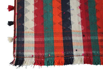 Jajim rug detail view: multicolored checkered and striped design, fringes along the edge.