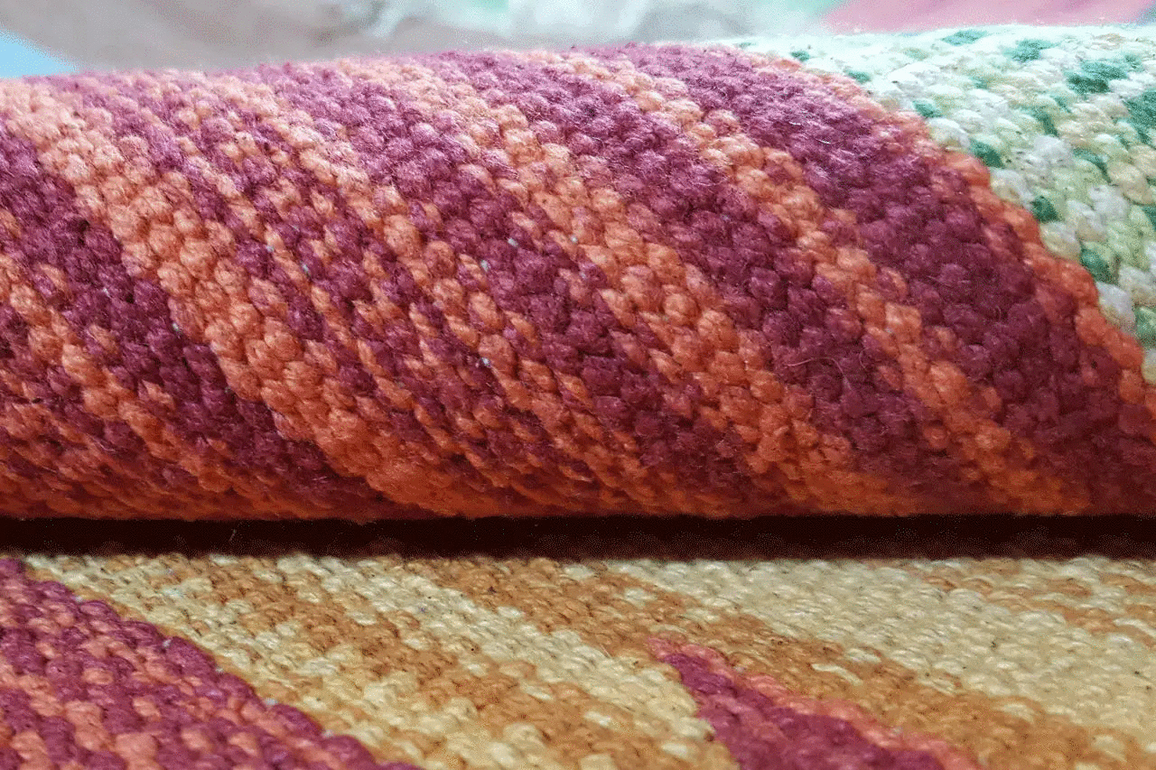 Close-up of kilim fabric with burgundy and beige stripes, visible weave texture