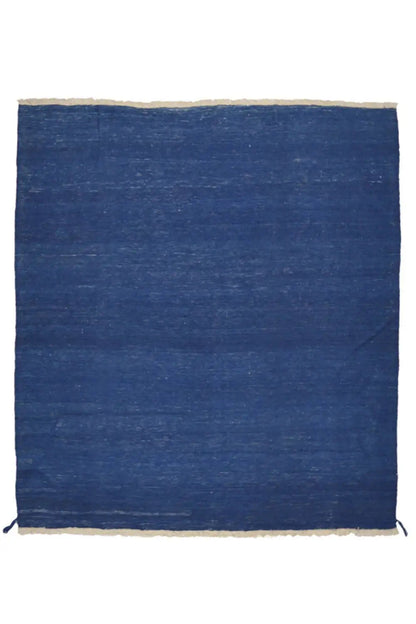 Blue kilim rug with a beige border and fringes on all sides