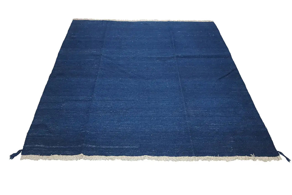 Triangularly folded blue kilim rug with a beige border and fringe