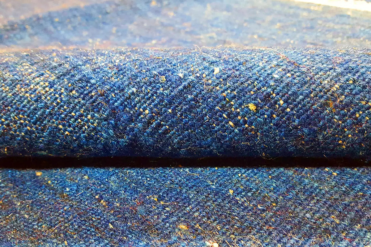 Blue kilim rug with a mottled texture and gold accents
