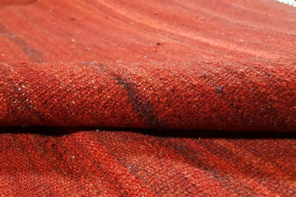Close-up of a red kilim rug Simple: dense pile with a fine, grainy pattern