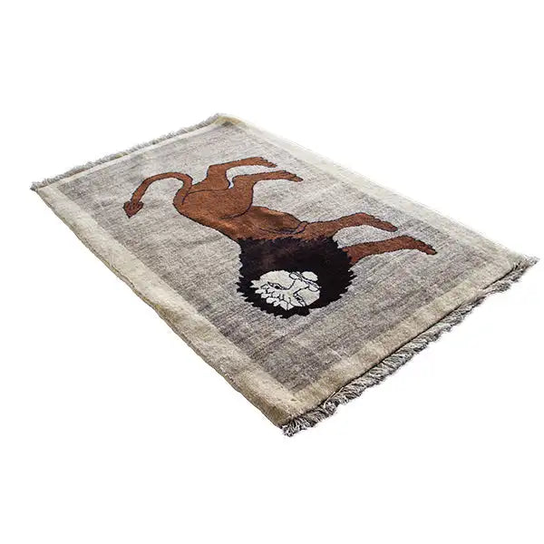 Gabbeh rug with lion motif: brown animal with a black mane on a light beige background