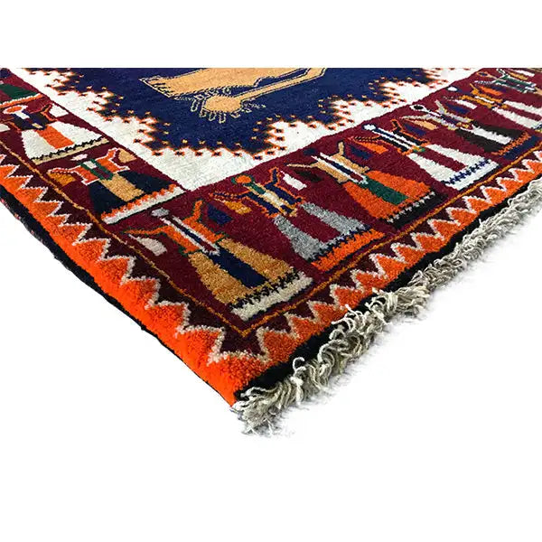 Gabbeh rug corner with fringe, multicolored border, and partial animal figure