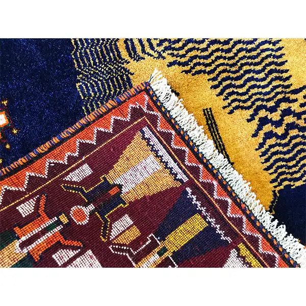 Gabbeh rug detail with geometric patterns, yellow-red areas, and a light pile