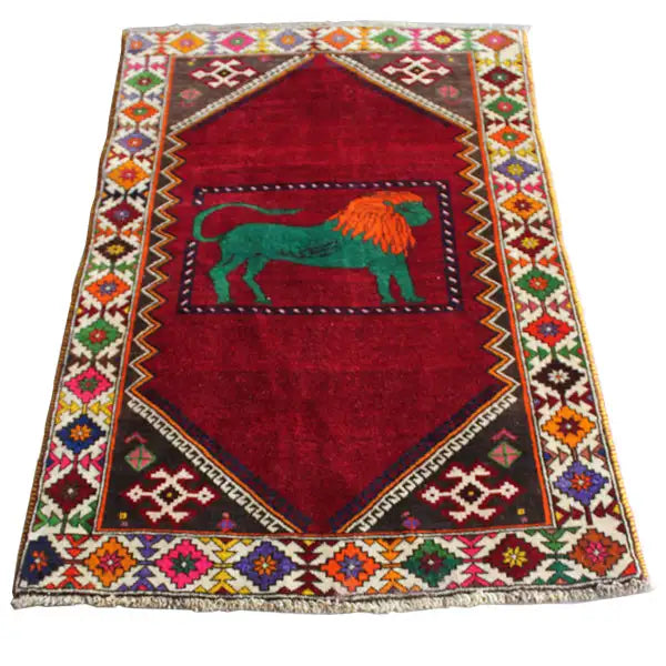 Gabbeh rug with red field, green lion, and multicolored decorative border