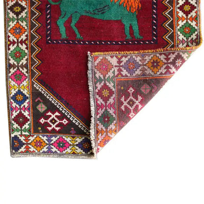 Gabbeh rug detail: red inner field, green lion motif and multicolored border