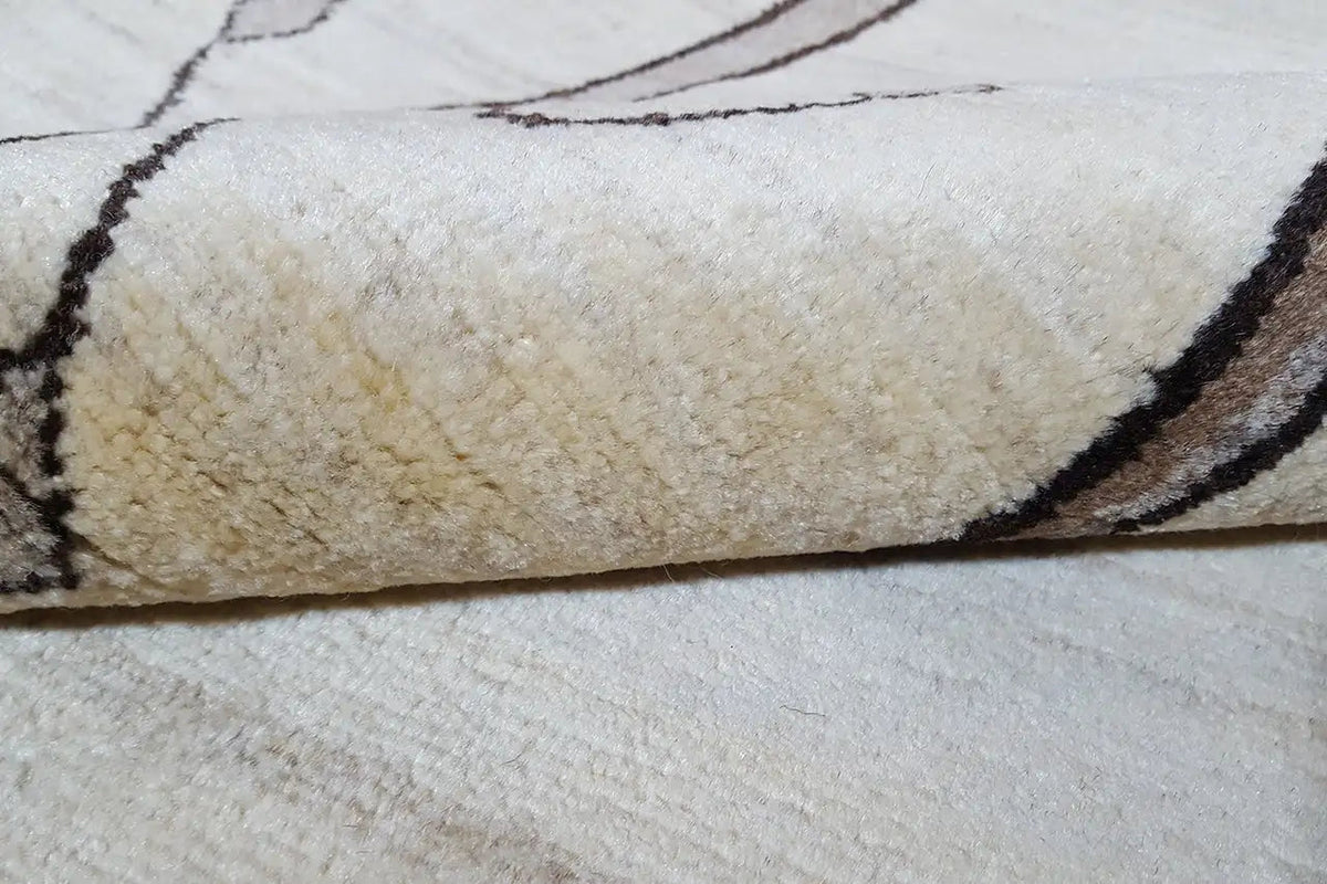 Close-up: cream carpet felt with a dark outline along the edge, lion pattern in the background