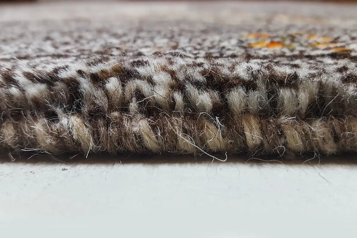 Edge area of a Gabbeh rug: dense pile with beige and colorful accents