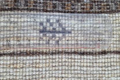 Gabbeh rug in detail with a tape measure over the pattern and border