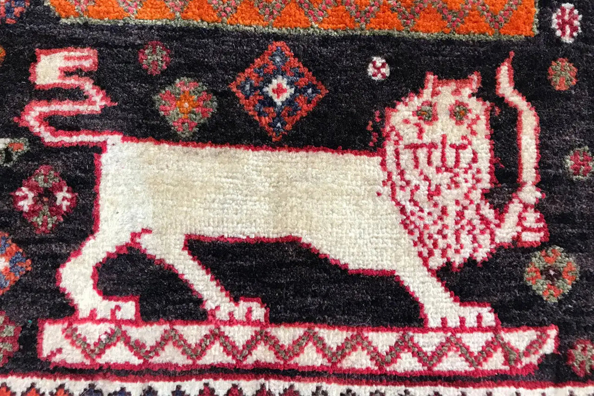 Carpet Poschti Qashqai close-up: white animal motif on a dark background