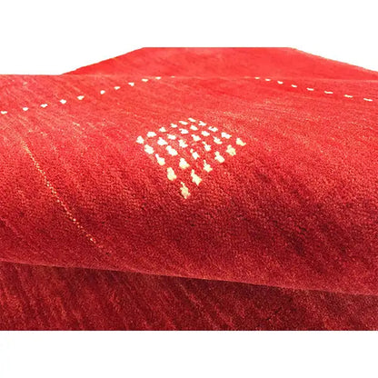 Red Gabbeh rug in detail: fluffy pile and light diamond pattern