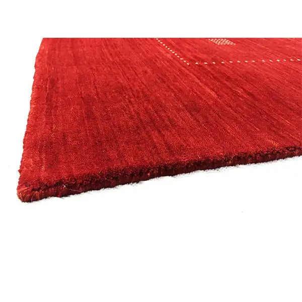 Red Gabbeh rug with a visible edge and fine pile surface
