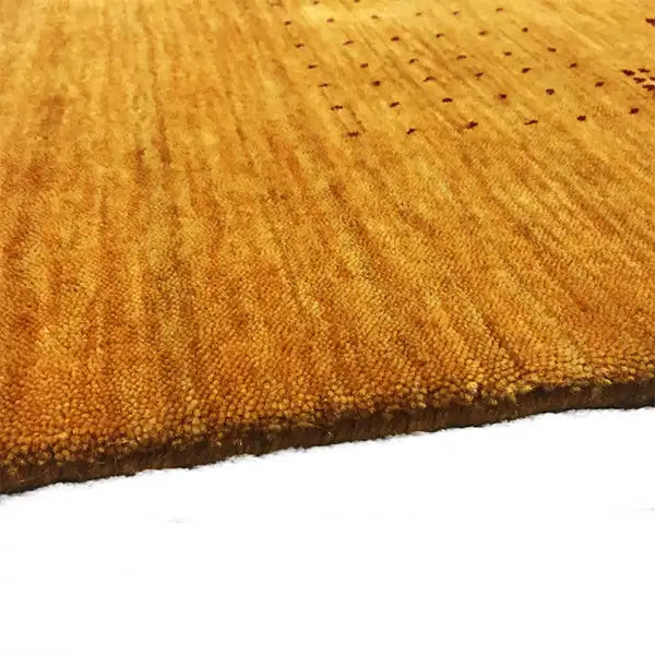 Gabbeh loom rug: close-up of the texture with a dense pile surface and curved edge