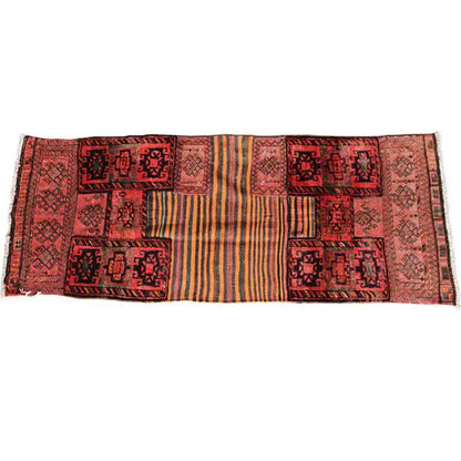Kilim rug spread out horizontally with repeated patchwork panels in red and beige