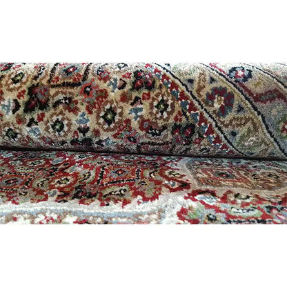 Carpet detail with a dense pile and colorful ornamental pattern in red, blue, and beige