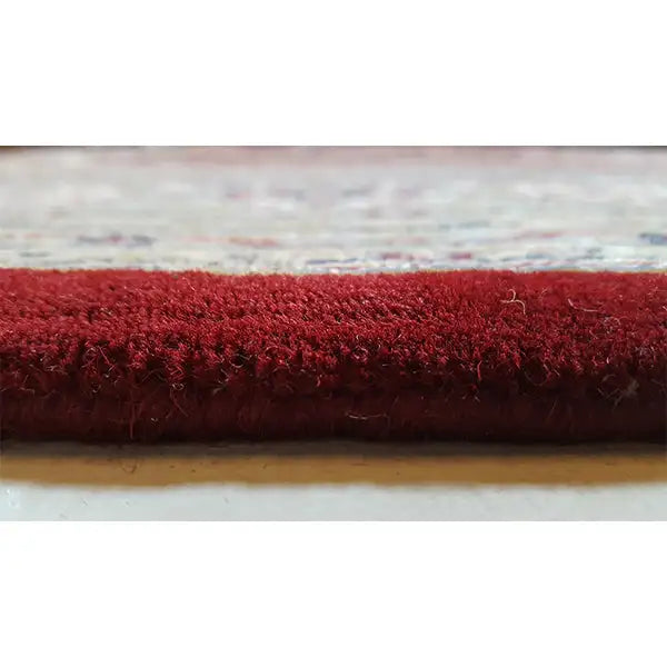 Carpet edge with red pile and a short fringed lower edge