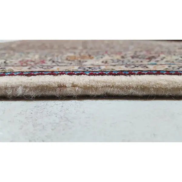 Rug edge with a multicolored border and short fringes, velvety pile surface