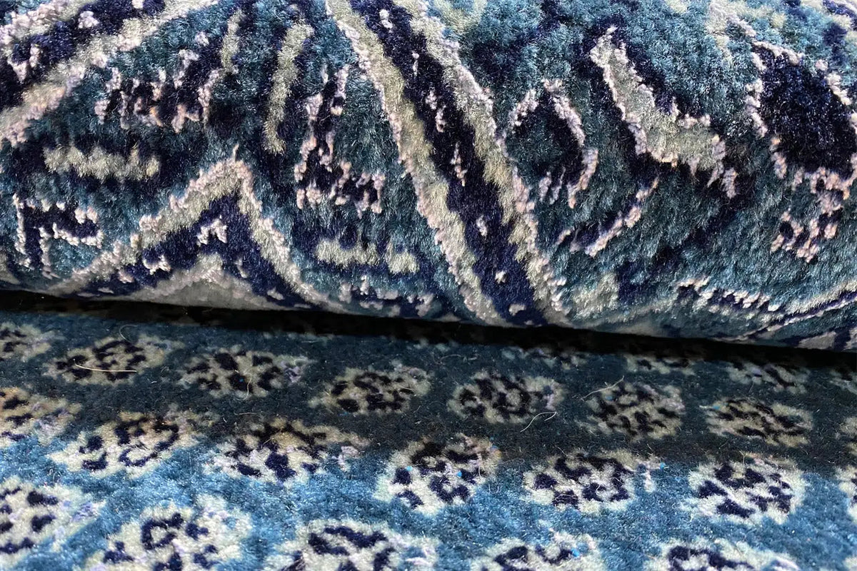 Detail of the blue carpet fabric with ornamental stripes in dark and light blue