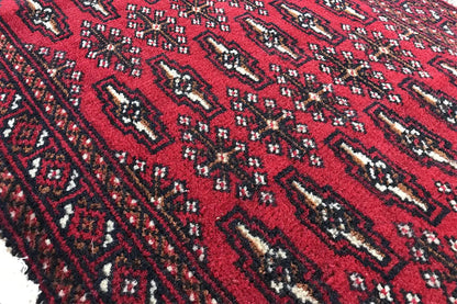 Close-up of a Turkmen carpet: dark red ground fabric with contrasting ornaments