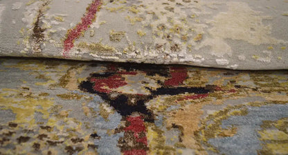 Round modern rug with a yellow-gray pattern and a visible pile edge.
