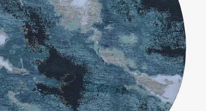 Close-up of the round designer rug: abstract blue-and-beige pattern, textured.
