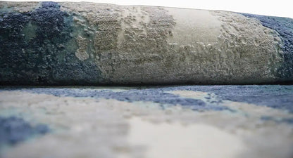 Detail of the round designer rug: aged look, blue and beige tones in the pattern.