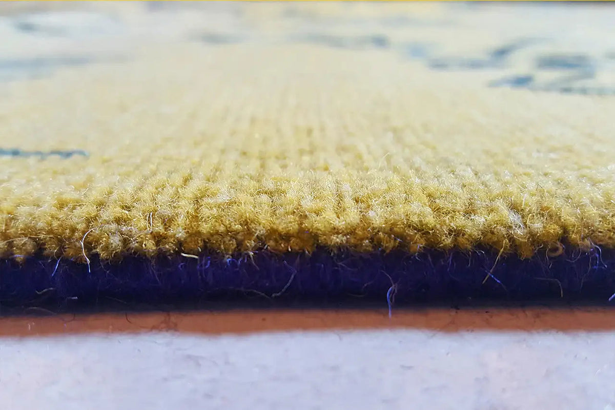Design rug detail: pile height with a yellow top and dark blue edge