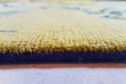 Design rug detail: pile height with a yellow top and dark blue edge