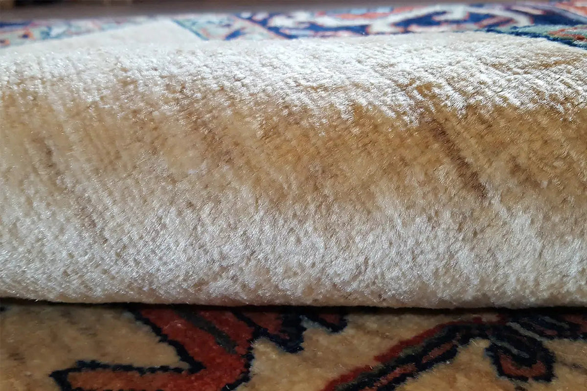 Carpet pile on a cream-colored field with a dense, textured surface and patterned area