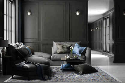 Oriental rug with a blue pattern and fringe, lying on a dark floor