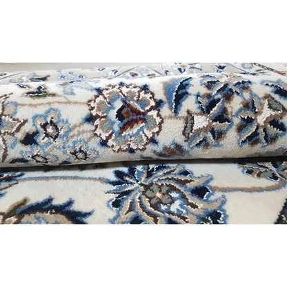 Close-up: beige rug with a blue floral pattern and densely woven surface