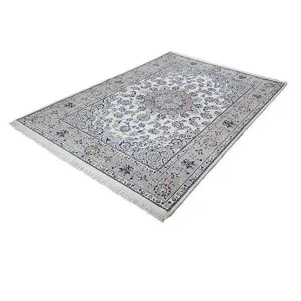 Rectangular rug with a cream-colored base, blue-gray ornaments, and fringes