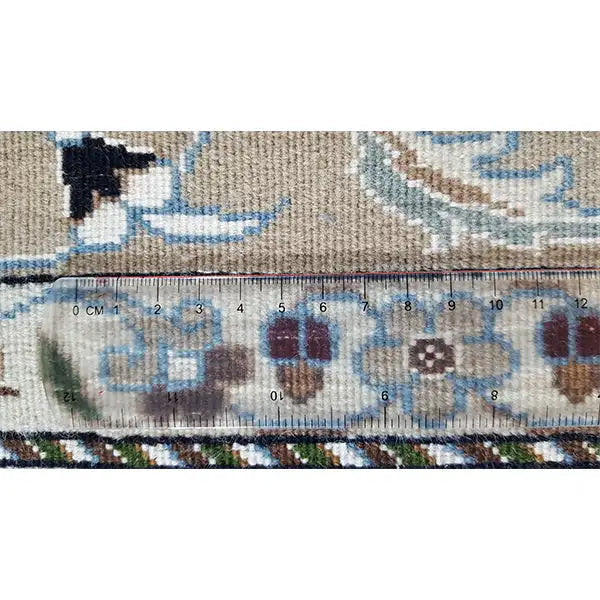 Carpet edge with blue pattern and tape measure indicating the size