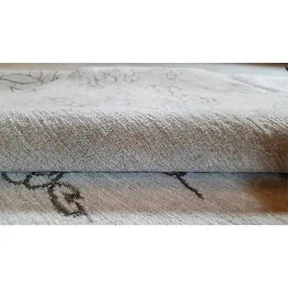 Designer rug with Bo Hamsa: close-up of the pile and edge, light gray pattern