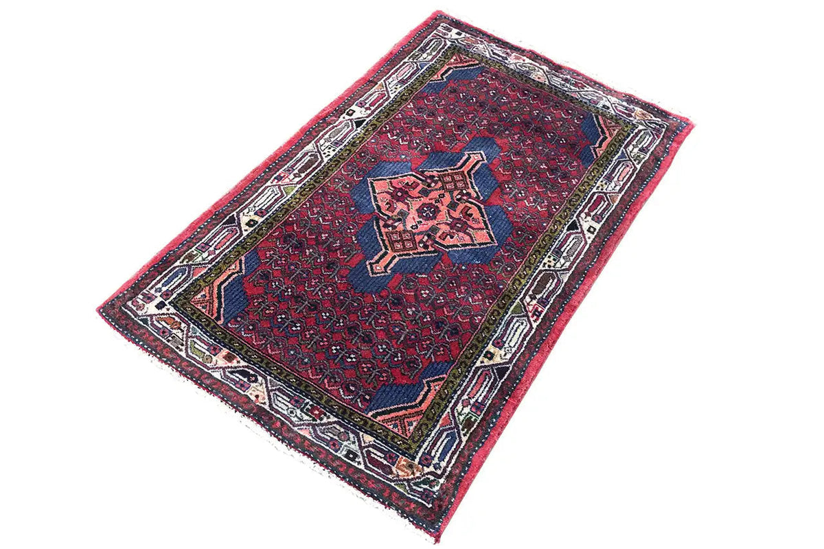 Red and dark blue oriental rug with a geometric medallion and multicolored border