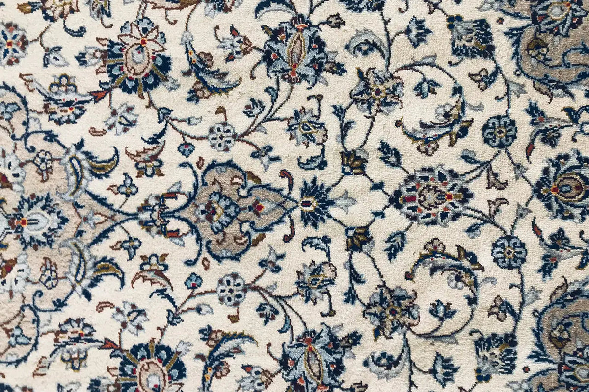 Detail of an Oriental rug: delicate blue vines and floral ornaments on a light background