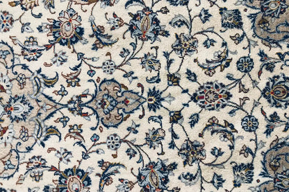 Detail of an Oriental rug: delicate blue vines and floral ornaments on a light background