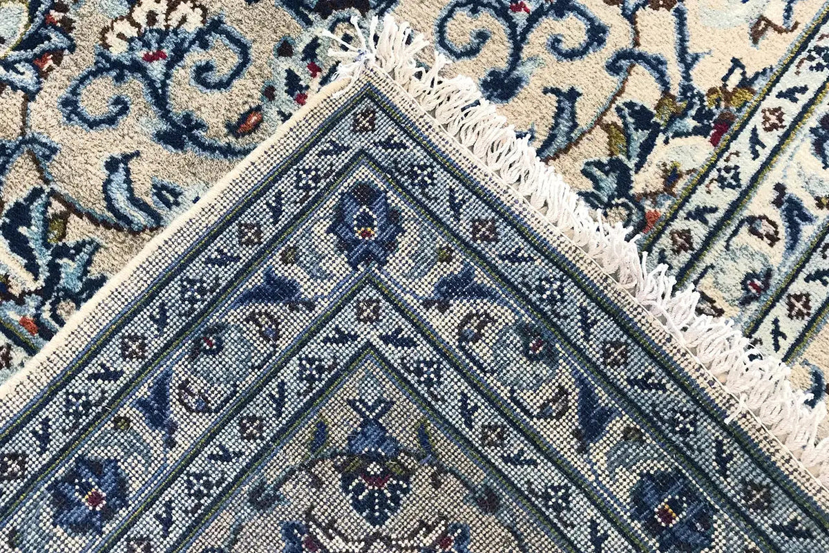 Close-up: fringes along the edge and a blue geometric and ornamental pattern